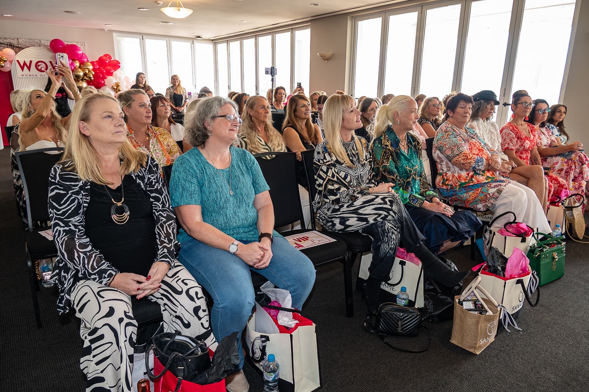 Attendees seated in rows facing the WOW backdrop